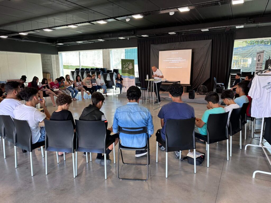 Young people from CEAPE sitting around a brother, listening to the Word