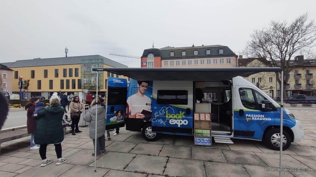 Book Expo van parked outdoors while some brothers distribute books